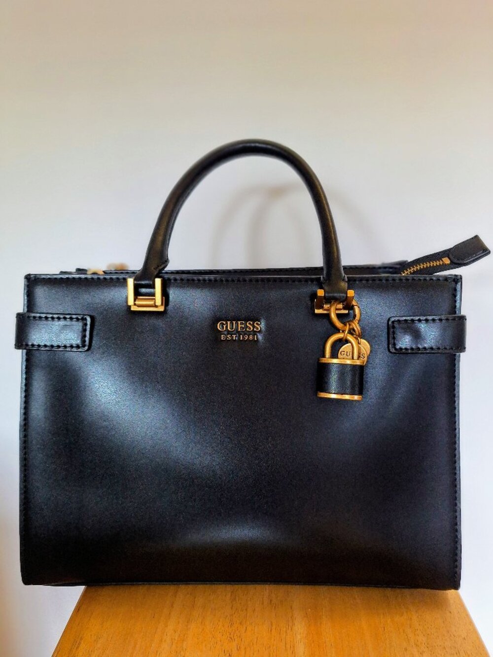Classic, structured black Guess handbag with matte gold hardware